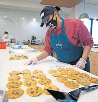  ?? [DOUG HOKE/ THE OKLAHOMAN] ?? Alisha Holland assembles an order for Catalyst Cookies, a social enterprise bakery for women of ReMerge.