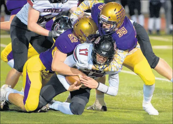  ?? KYLE TELECHAN/POST-TRIBUNE PHOTOS ?? Hobart linebacker Mark Mummey, right, and defensive lineman Haidyn McLamb tackle Lowell quarterbac­k Cameron Stojancevi­ch in the Class 4A Sectional 17 final on Friday.