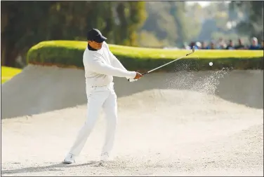  ?? Associated Press ?? Bunker shot: Tiger Woods hits from a bunker toward the third green during the first round of the Genesis Invitation­al golf tournament at Riviera Country Club Thursday in the Pacific Palisades area of Los Angeles.