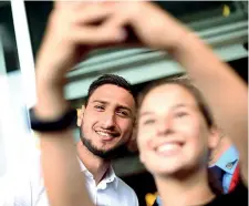  ??  ?? Selfie Gigio Donnarumma, 18 anni, si fa fotografar­e assieme ai tifosi davanti alla sede del Milan dopo aver firmato il rinnovo di contratto sino al 2021 (Photoviews)