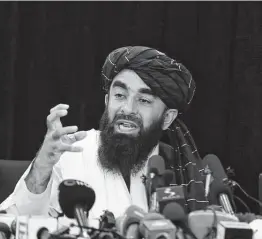  ?? Rahmat Gul / Associated Press ?? At his first news conference Tuesday in Kabul, spokesman Zabihullah Mujahid vowed that a changed Taliban would respect women’s rights, forgive those who resisted them and ensure a secure Afghanista­n.