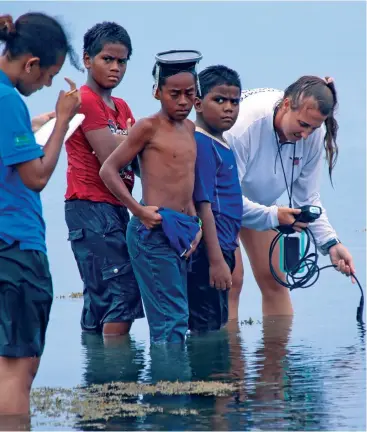  ?? ?? Seagrass researcher Carrie Wentzel with Marine Scientist Susana Tauyavuca being assisted by a few children of Waiqori village, Oneata on March 19, 2022. Photo:Kelera Sovasiga