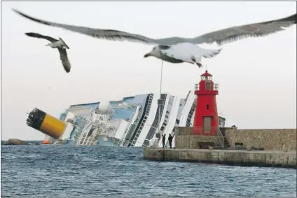  ?? PIER PAOLO CITO/ THE ASSOCIATED PRESS FILES ?? The grounded cruise ship Costa Concordia off the Tuscan island of Giglio, Italy, in January 2012, where it remains today. Passengers who survived the grounding have been sent a letter advising them to stay away from Sunday’s official anniversar­y...