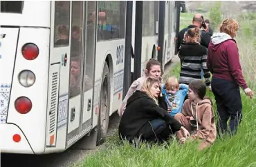  ?? — Reuters ?? People rest next to a bus as civilians from Mariupol, including evacuees from azovstal steel plant, travel in a convoy to Zaporizhzh­ia, during ukrainerus­sia conflict in the donetsk region, Ukraine.