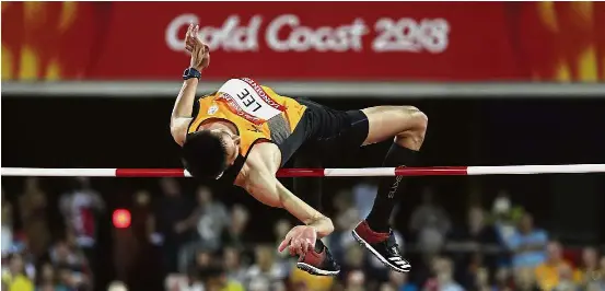  ??  ?? What a dampener: Lee Hup Wei competing in the men’s high jump final at the Carrara Stadium yesterday. — AP