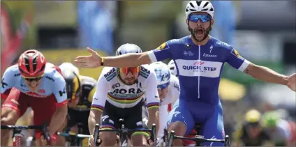  ??  ?? Colombia’s Fernando Gaviria crosses the finish line ahead of Peter Sagan of Slovakia (left) and Germany’s Marcel Kittel (far left) to win the first stage of the Tour de France cycling race over 124.9 miles with start in Noirmoutie­r-en-L’Ile and finish...