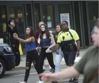  ?? NICOLAUS CZARNECKI PHOTOS / HERALD STAFF ?? SHUT DOWN: Police escort shoppers away from South Shore Plaza after a shootout inside. Above right, a tactical team assembles.