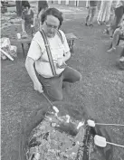  ?? ?? Oswyn Wormley, of Norman, roasts marshmallo­ws for s’mores at the outdoor Shavuot campout at Temple B’nai Israel in Oklahoma City.