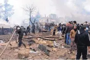  ?? SAIF ALNAJDI/ASSOCIATED PRESS ?? Rescue workers attend to the wreckage after almost 50 were killed when a car bomb went off in a busy market in the rebel-held Syrian town of Azaz on Saturday.