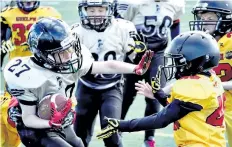  ?? VINCE ANGELINI/SPECIAL TO POSTMEDIA NEWS ?? Niagara Generals back Austin MacRae, left, stretches out his arm to keep the ball away from a Guelph defender in atom football Saturday at Kiwanis Field in St. Catharines.