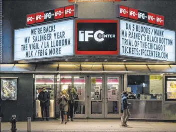  ?? Mary Altaffer The Associated Press ?? Kathyn Dennet, center, and Brian Haver leave the IFC Center in New York on Friday after viewing a screening of “Mank.”