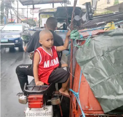  ?? PHOTOGRAPH BY ALFONSO PADILLA FOR THE DAILY TRIBUNE @tribunephl_al ?? IT may just be a fun ride for this boy in his father’s trike not knowing that health and safety protocols are being violated by not wearing mask and going out on a limb in his young age.