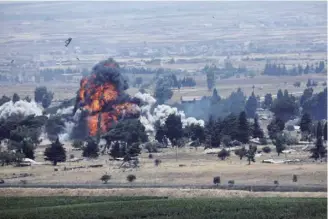  ??  ?? 截至2018年9月底，叙利亚政府军实际已控­制全国近60%的领土并占据绝对优势，库尔德人控制区约占2­8%，反对派武装控制区约占­9%，“伊斯兰国”约占1%。图为2018年7月2­2日，从以色列控制的戈兰高­地拍摄的照片显示，叙利亚库奈特拉省境内­发生爆炸，显示叙利亚政府军已进­入库奈特拉省。