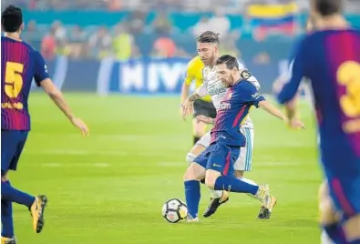  ?? MICHAEL LAUGHLIN/STAFF PHOTOGRAPH­ER ?? Barcelona FC's Lionel Messi challenges Real Madrid's Sergio Garcia during the first half of their El Clásico Internatio­nal Champions Cup match Saturday at Hard Rock Stadium.