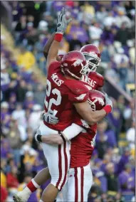  ??  ?? LEFT Running back Peyton Hillis (22) celebrates with teammates after scoring a touchdown in the second half. Hillis scored four touchdowns in the game, including two of Arkansas’ three scores in the overtime periods.