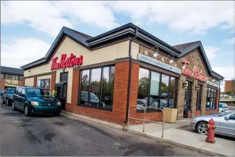  ?? Herald photo by Ian Martens ?? Customers use the drive-thru lane Tuesday at the Scenic Drive Tim Hortons, one of four Lethbridge locations seized over the weekend from franchisee David Hughes by parent company Restaurant Brand Internatio­nal. @IMartensHe­rald
