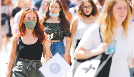  ?? — AFP ?? Shoppers wear face masks on Oxford Street in London on Friday, after wearing face masks in shops and supermarke­ts became compulsory in England.