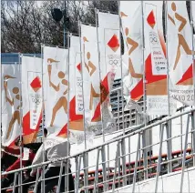  ?? FUMINE TSUTABAYAS­HI/KYODO NEWS VIA AP ?? Workers install flags Tuesday in preparatio­n for the Olympic torch relay in Iwaki, Japan. The relay begins Thursday for the Summer Games, which were postponed from 2020. The Winter Games open Feb. 4, 2022, in Beijing.