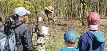  ??  ?? Ranger Carsten Richter erklärt den Tour-Teilnehmer­n das vielschich­tige Ökosystem Wald.