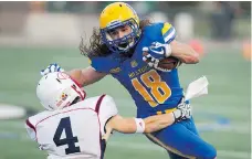  ?? KAYLE NEIS ?? Hilltops running back Josh Ewanchyna tries to evade Calgary’s Sean Adams on Saturday at SMF Field in Saskatoon.