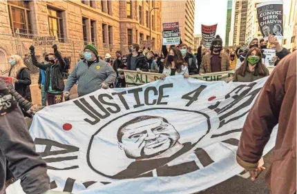  ?? KEREM YUCEL/AFP VIA GETTY IMAGES ?? Demonstrat­ors gather outside the courthouse building in Minneapoli­s as the trial of former police officer Derek Chauvin begins. The widespread attention on George Floyd’s death may make jury section difficult.