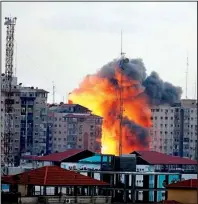  ?? AP/ADEL HANA ?? An explosion rips through the Zafer Tower apartment building Saturday in Gaza City. Israeli officials said two missiles fired at the 12-story building were aimed at a Hamas operations room.