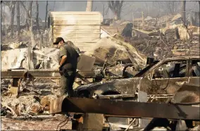  ?? AP PHOTO/NOAH BERGER ?? Sheriff’s Deputy McCabe searches Cache Creek Mobile Home Estates where the Cache Fire leveled dozens of residences on Wednesday in Clearlake, Calif.