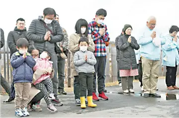  ?? — Reuters photo ?? People pray to mourn victims at 2.46pm, the time when the magnitude 9.0 earthquake struck off Japan’s coast in 2011, in Iwaki, Fukushima prefecture, to mark the eighth year anniversar­y of the earthquake and tsunami that killed thousands and set off a nuclear crisis.