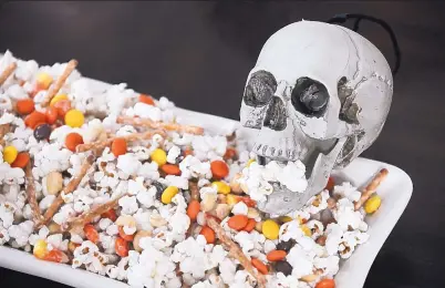  ?? TRAVIS HEYING/TRIBUNE NEWS SERVICES ?? Impress Halloween party guests with this colorful, white-chocolate coated popcorn mix.