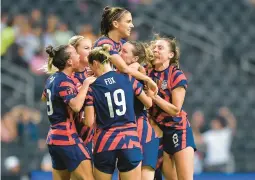  ?? AZAEL RODRIGUEZ/GETTY ?? Alex Morgan, top, celebrates with teammates after scoring the eventual game-winner against Canada in the CONCACAF W title game Monday night in Mexico.