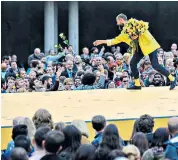  ??  ?? Saying it with flowers: the crowds appreciate­d the 160 people who paraded on a 100m catwalk installed high above the ground as part of What Is The City But
The People? show in Piccadilly Gardens, Manchester