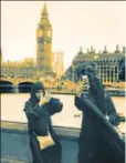  ?? REUTERS ?? Two women in burqas clicking photograph­s opposite the Houses of Parliament, London, Britain