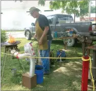  ?? Westside Eagle Observer/SUSAN HOLLAND ?? Blacksmith Steve Low, of Gentry, set up his forge under a tree on the grounds of the Gravette Historical Museum and gave blacksmith­ing demonstrat­ions during the Gravette Day Dutch oven cook-off activities. Here he waits for a piece of metal to get hot before forming it with his hammer. Low also displayed metal kitchenwar­e and tools he has made.