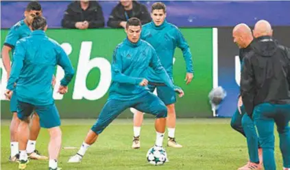  ?? AFP ?? Observado pelo técnico Zinedine Zidane (D), Cristiano Ronaldo participa da roda de bobo do treino do Real