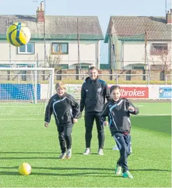  ?? Picture: Paul Reid. ?? Trust developmen­t officer Adam McWilliam takes a football coaching session with local youngsters.