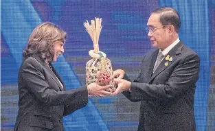  ?? ?? OVER TO YOU: Prime Minister Prayut Chano-cha hands a ceremonial chalom (a round bamboo basket) to US Vice President Kamala Harris at the conclusion of the Apec summit at the Queen Sirikit National Convention Center in Bangkok yesterday. The US will host next year’s Apec summit.