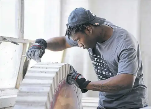  ?? Pam Panchak/Post-Gazette ?? Herbert Walker of Homewood puts the finishing touches on a project Tuesday at the Trade Institute of Pittsburgh in Homewood.