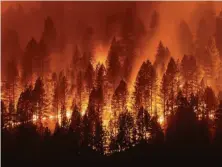  ?? Noah Berger / Associated Press ?? The Dixie Fire burns down a hillside toward Diamond Mountain Road near Taylorsvil­le (Plumas County) on Friday.