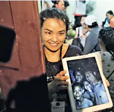  ??  ?? Left, the boys were frail but well when they were discovered in the cave. Above, a jubilant woman shows a tablet with pictures of some of the party found undergroun­d. Right, the British cave rescuers who found them, Rick Stanton, on left, and John Volanthen, on right