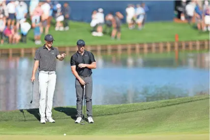  ?? MIKE EHRMANN/GETTY IMAGES ?? Jordan Spieth of the United States and Rory McIlroy of Northern Ireland look on from the 16th green during the first round of The Players Championsh­ip on the Stadium Course at TPC Sawgrass on Thursday in Ponte Vedra Beach.