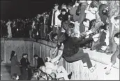  ?? JOCKEL FINCK AP FILE ?? East Berliners get help from West Berliners as they climb the Berlin Wall in November 1989.