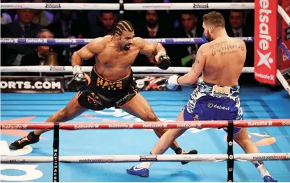  ?? — AFP ?? LONDON: British boxer David Haye (L) goes on the offensive against compatriot Tony Bellew (R) during their heavyweigh­t boxing match at the O2 Arena in London on Saturday. Tony Bellew stunned bitter rival David Haye to win their eagerly-awaited...