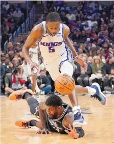  ?? MARK J. TERRILL/ASSOCIATED PRESS ?? The Sacramento Kings’ De’Aaron Fox, top, and the Los Angeles Clippers’ Paul George go after a loose ball during Friday night’s game.