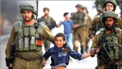  ?? MUSSA QAWASMA/REUTERS ?? MASIH PANAS: Tentara Israel menahan bocah laki-laki Palestina yang ikut protes di Hebron, Tepi Barat, wilayah yang saat ini dikuasai Fatah.