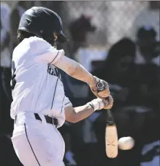  ?? ?? LEFT: Yuma Catholic lead off hitter Juan Lugo makes contact, driving the ball through the left side of the infield for a single in the bottom of the first inning of Saturday afternoon’s game.