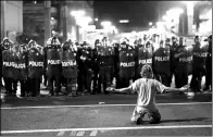  ?? SANDY HUFFAKER / REUTERS ?? A demonstrat­or taunts Police officials after a Donald Trump campaign rally in Phoenix, Arizona, on Tuesday.