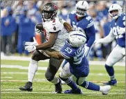  ?? MICHAEL CONROY / AP ?? Buccaneers running back Leonard Fournette is tackled by the Colts’ Darius Leonard during the first half Sunday in Indianapol­is. Fournette ran for 3 TDS and caught a fourth in Tampa Bay’s 38-31 victory.