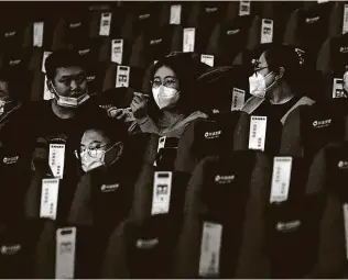  ?? Andy Wong / Associated Press ?? People wearing face masks to help curb the spread of the coronaviru­s chat with one another Thursday as they watch a film at Poly Cinema in Beijing.