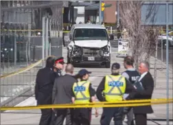  ?? The Canadian Press ?? Police are seen near a damaged van in Toronto after a van mounted a sidewalk crashing into a number of pedestrian­s on April 23.