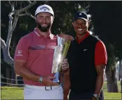  ?? RYAN KANG — THE ASSOCIATED PRESS ?? Jon Rahm holds the winner's trophy next to event host Tiger Woods after winning the Genesis Invitation­al.